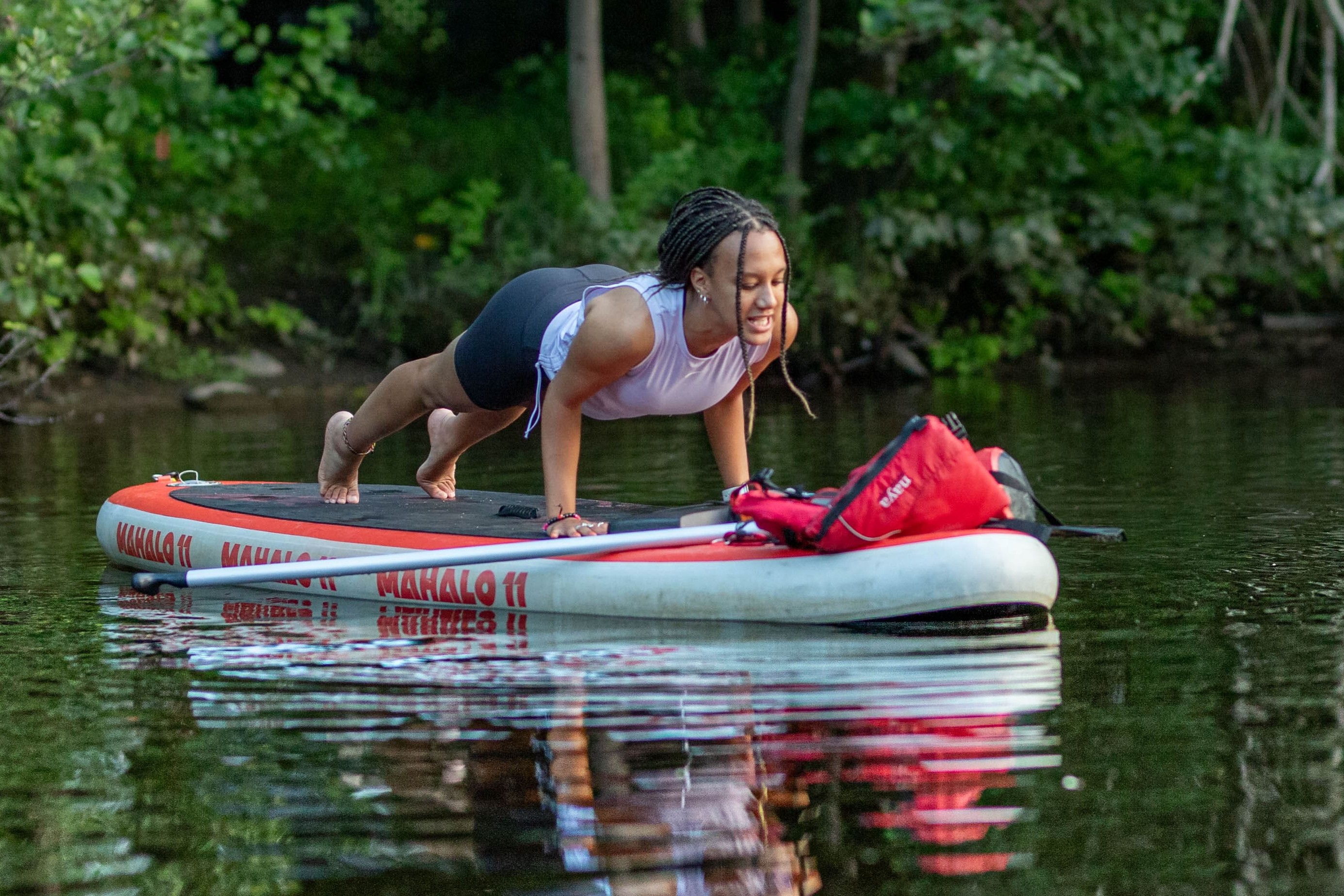 Position de yoga sur une planche à pagaie sur l'eau